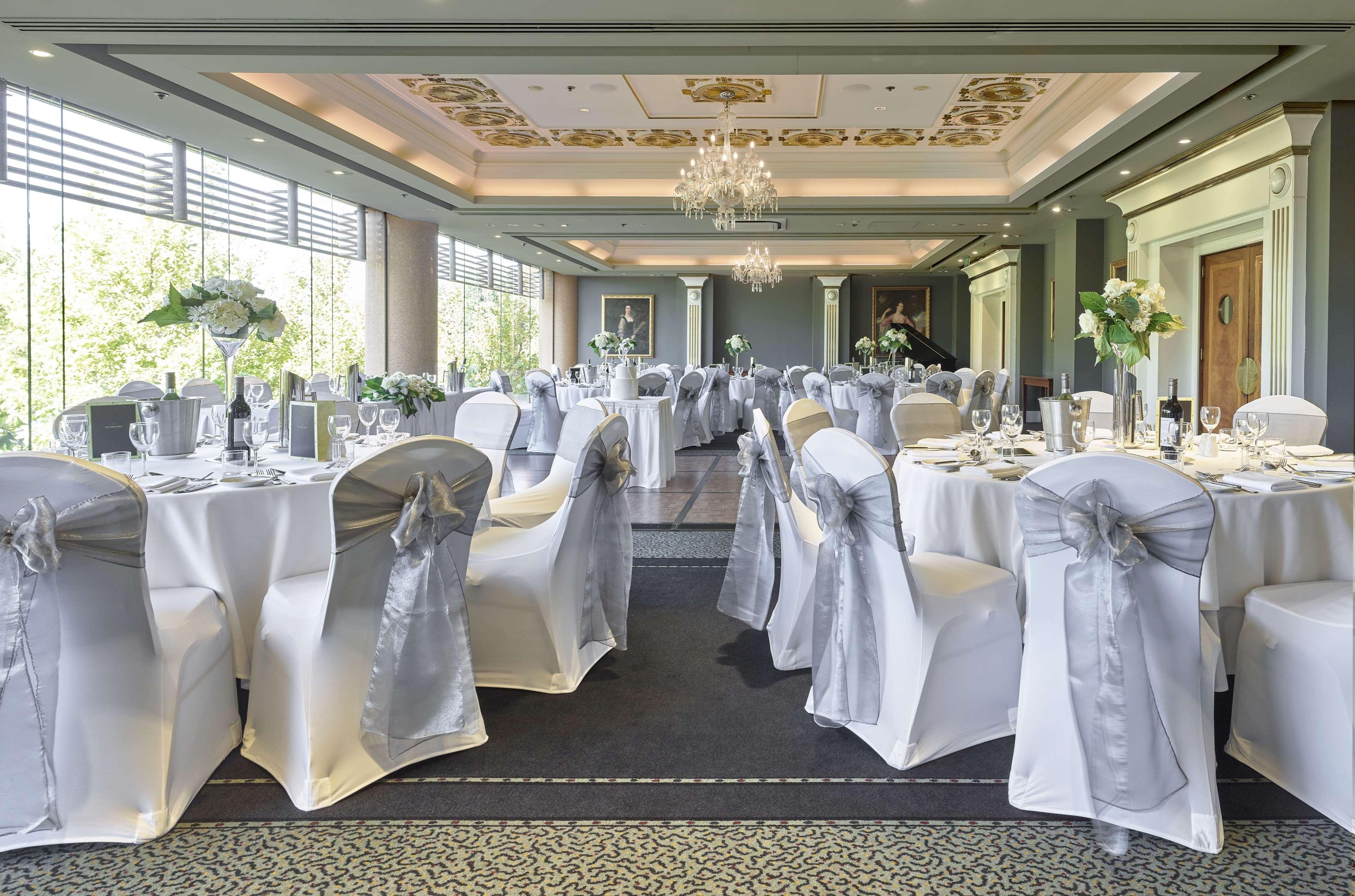 Hotel Stamford Plaza Adelaide Exterior foto The photo displays an elegantly arranged banquet hall. The room features several round tables covered with white tablecloths, each adorned with silver sashes on the chairs. There are floral centerpieces, possibly white flowers, on the tables, adding 